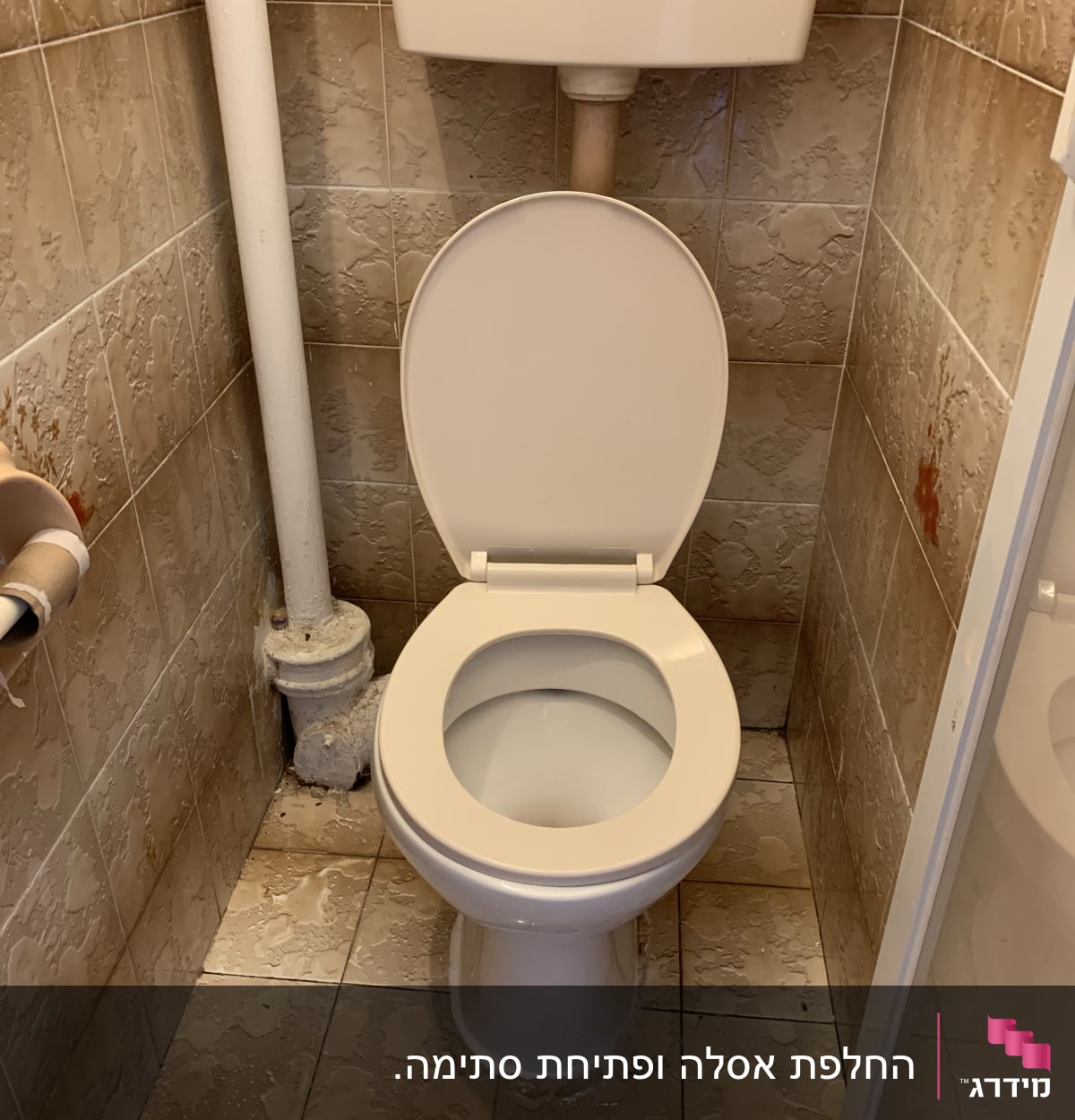 אסלה עם צינור מים וקיר אריחים